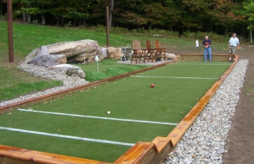 stained wood and inset gravel bordering an outdoor bocce court