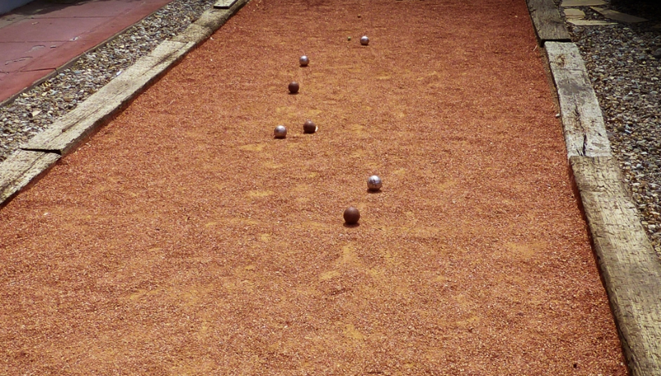 Red, clay bocce court with wood border