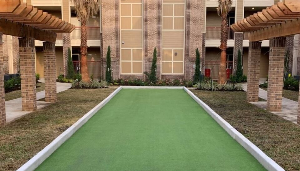 a bocce court in a hotel courtyard with a clean, raised concrete border