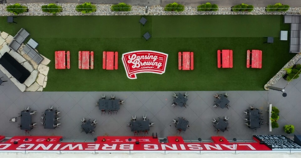 aerial view of outdoor space at Lansing Brewing Company with picnic tables and bocce courts for emlpoyees to enjoy