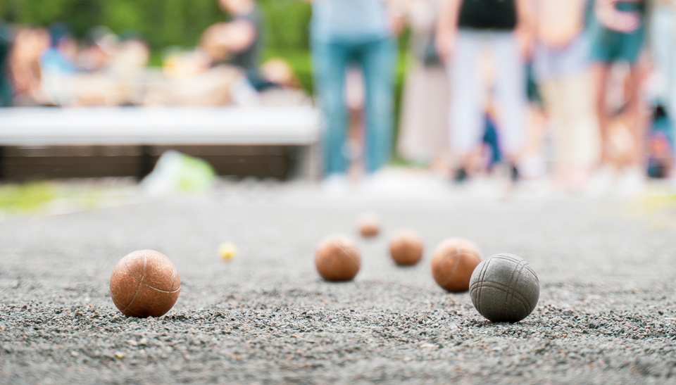 Grey oyster shell bocce court surfacing with people playing