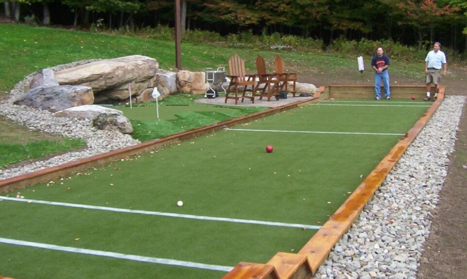 a wood bordered bocce court with packed gravel edging for drainaged to help preserve wood
