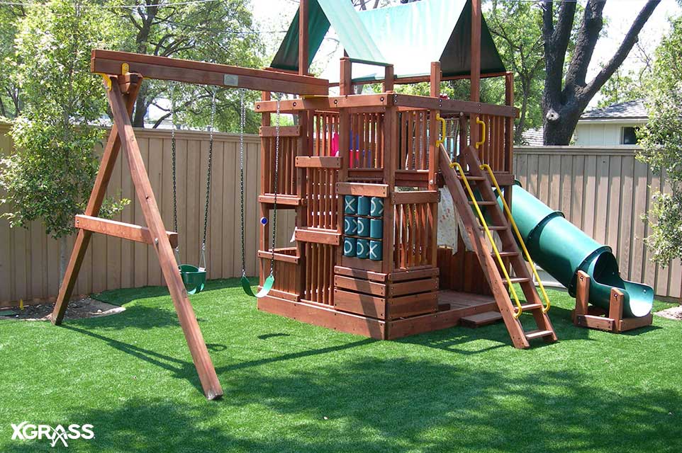 Backyard playground with synthetic turf installed