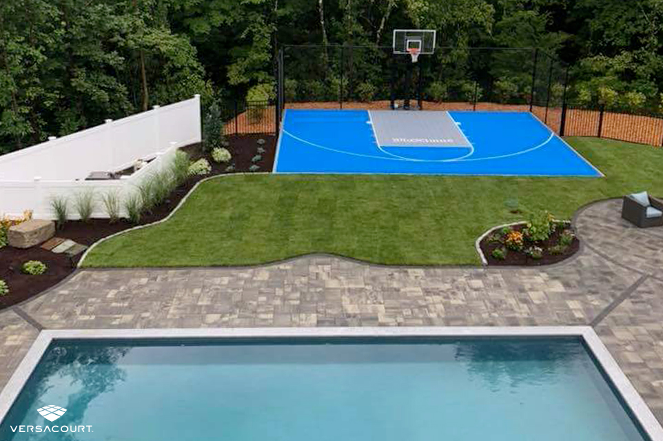 VersaCourt basketball court installed next to the swimming pool in a large backyard