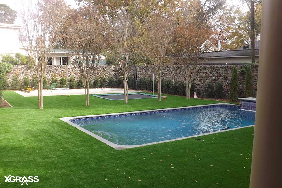 Slip resistant artificial grass installed next to backyard pool