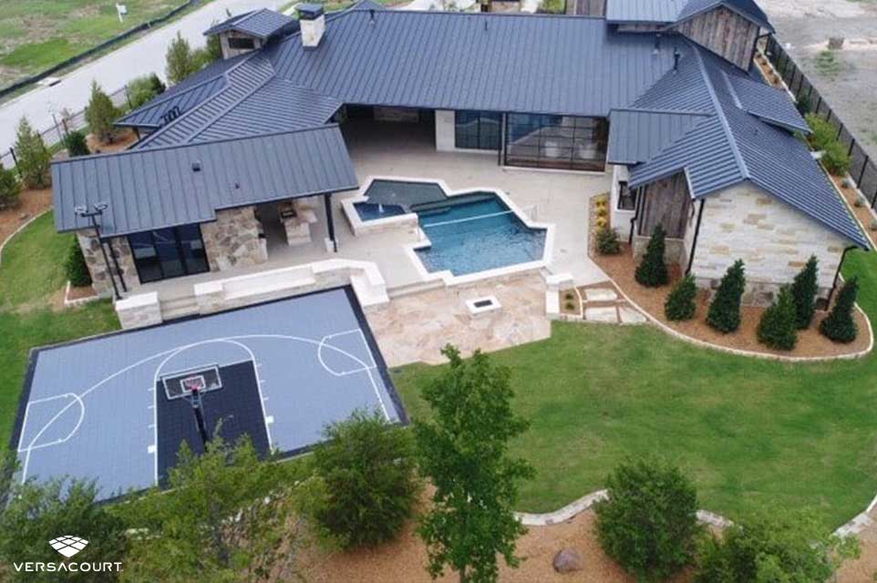 A large home installed with a multi-sport game court next to the backyard pool