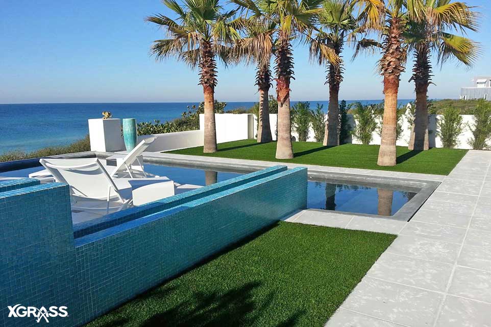 Seaside home backyard pool with synthetic turf installed around it