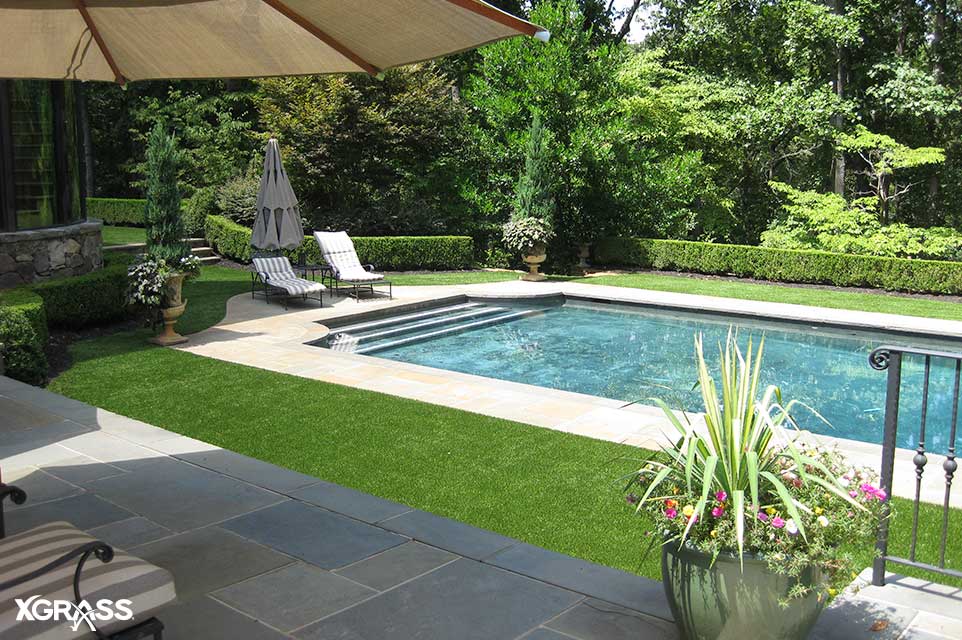 Luxurious backyard pool installed with low maintenance artificial grass