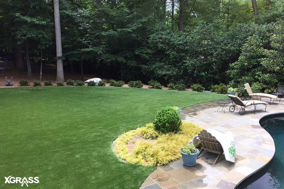 Low maintenance artificial grass lawn installed next to a backyard pool