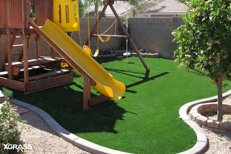 Small backyard with playground installed with artificial turf