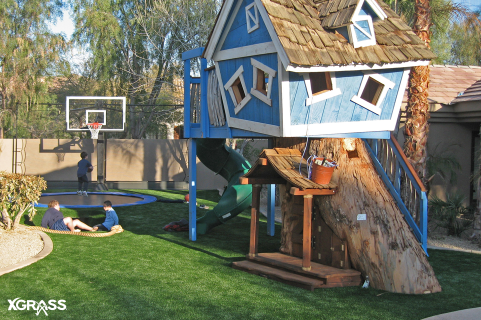 Small backyard playground area installed with artificial turf