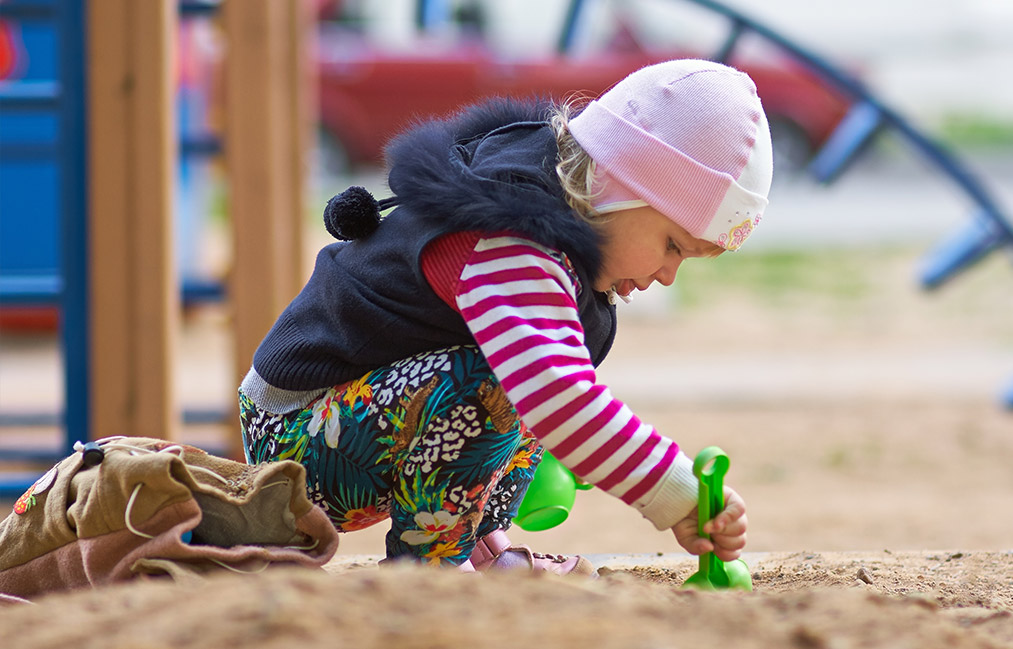 kid playing in sand