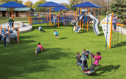 Kids playing on a playground covered by XGrass turf
